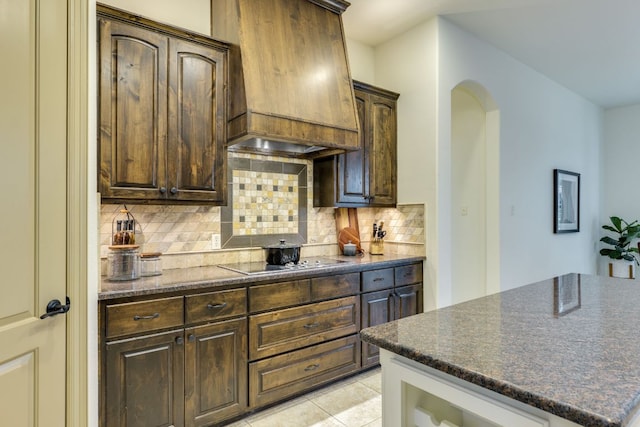 13708 Montview Dr, Austin, TX 78732 - kitchen with black electric cooktop, premium range hood, tasteful backsplash, arched walkways, and dark brown cabinetry