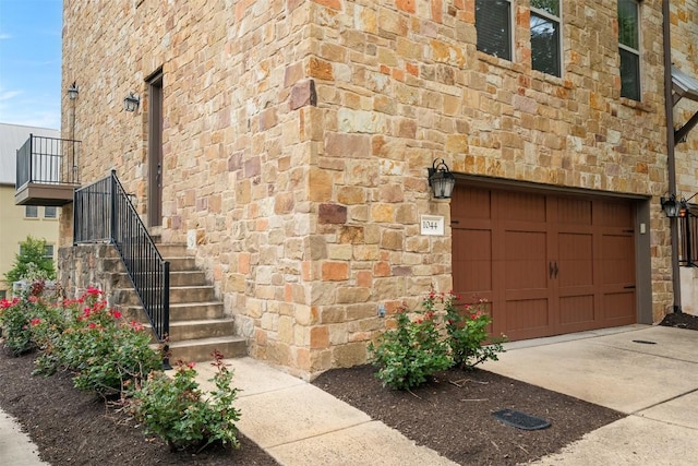 1044 Highknoll Ln, Georgetown, TX 78628 - view of home's exterior with stone siding, concrete driveway, an attached garage, and stairway