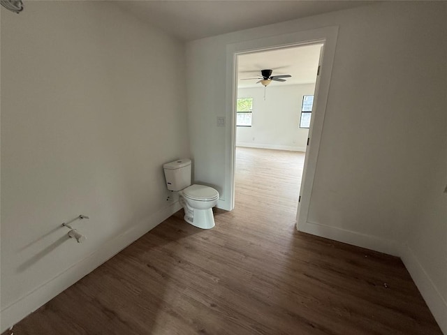 spare room with wood finished floors, baseboards, and a ceiling fan