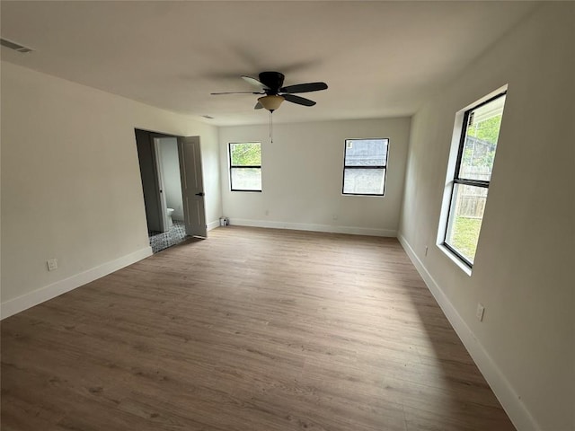 unfurnished room featuring ceiling fan, wood finished floors, and baseboards