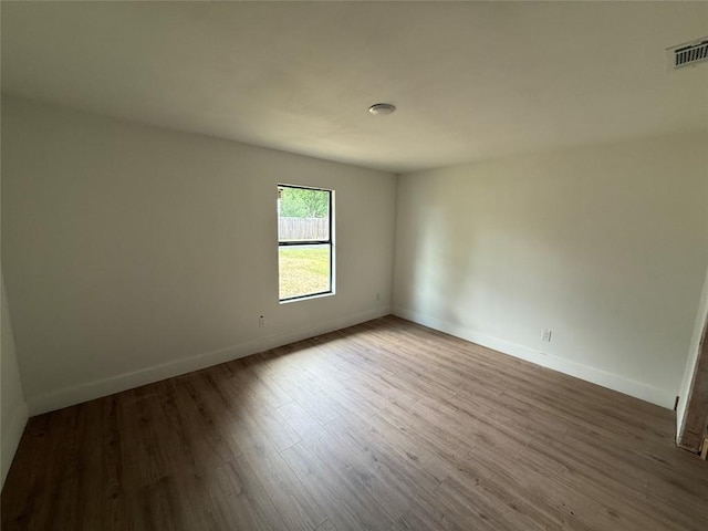 empty room with wood finished floors and baseboards