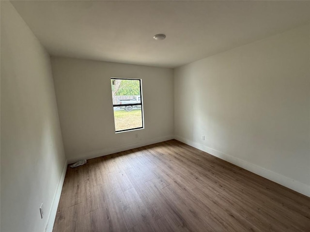 spare room with wood finished floors and baseboards