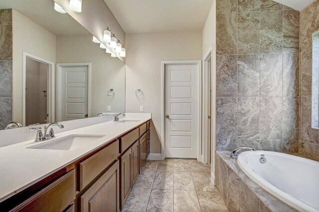 bathroom with a bath and double vanity