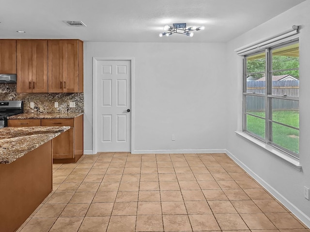 1801 Rock Creek Dr, Round Rock, TX 78681 - kitchen with stainless steel electric stove, brown cabinets, ventilation hood, and dark stone counters