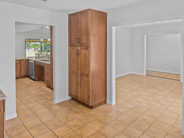 1801 Rock Creek Dr, Round Rock, TX 78681 - kitchen featuring a sink, brown cabinetry, stainless steel dishwasher, and light tile patterned floors