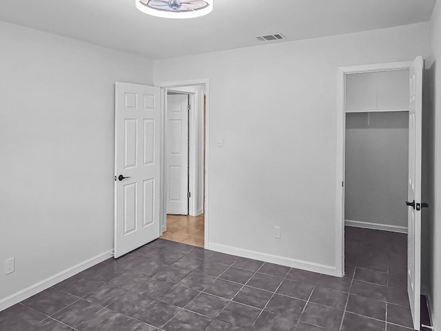 1801 Rock Creek Dr, Round Rock, TX 78681 - unfurnished bedroom featuring dark tile patterned flooring, a closet, a walk in closet, and baseboards