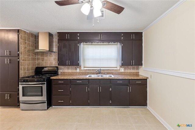 1518 S 37th St, Temple, TX 76504 - kitchen featuring stainless steel range with gas stovetop, wall chimney exhaust hood, a sink, decorative backsplash, and ceiling fan