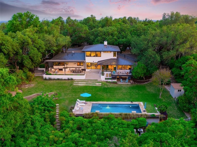 402 Buckeye Trl, West Lake Hills, TX 78746 - back of house at dusk featuring an outdoor pool, a patio area, a yard, a wooden deck, and a gazebo