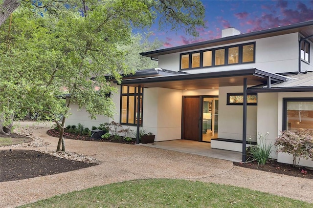 402 Buckeye Trl, West Lake Hills, TX 78746 - back of house featuring stucco siding, metal roof, a chimney, and a standing seam roof