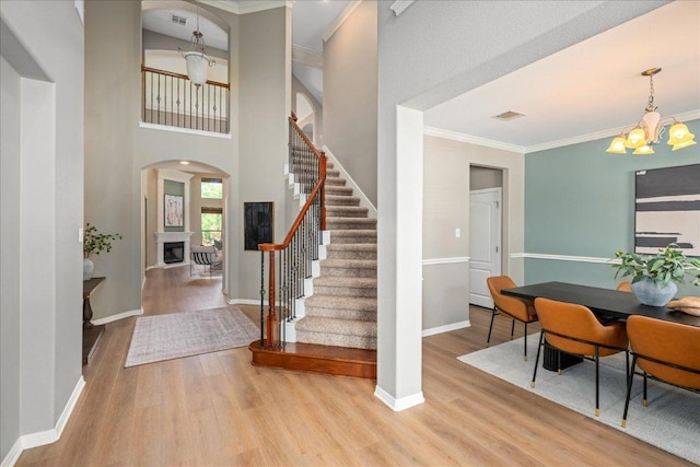 12920 Little Dipper Path, Austin, TX 78732 - entryway featuring a chandelier, wood finished floors, crown molding, stairs, and baseboards