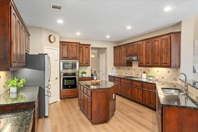 12920 Little Dipper Path, Austin, TX 78732 - kitchen with stainless steel appliances, a sink, light wood-style floors, tasteful backsplash, and recessed lighting