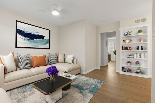 2401 Manor Rd Unit 235, Austin, TX 78722 - living room with wood finished floors, ceiling fan, baseboards, and built in features