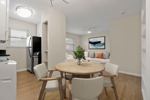 2401 Manor Rd Unit 235, Austin, TX 78722 - dining area featuring baseboards, light wood-style floors, a ceiling fan, and stacked washer and clothes dryer