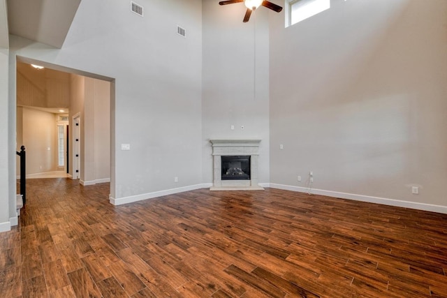 3351 Vasquez Pl, Round Rock, TX 78665 - unfurnished living room featuring a towering ceiling, a ceiling fan, dark wood-style flooring, and a glass covered fireplace