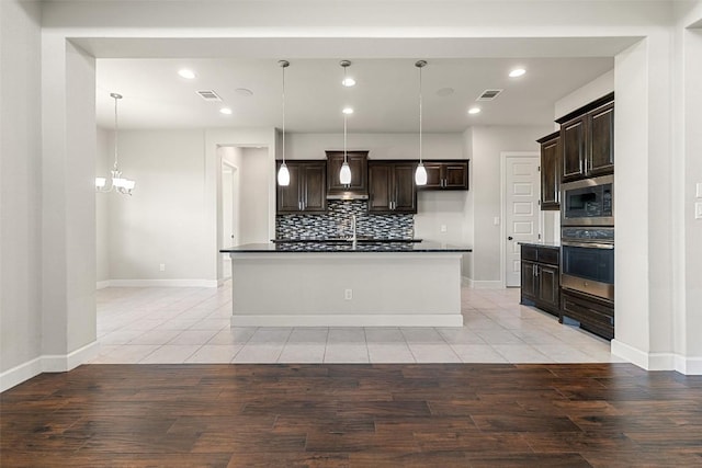 3351 Vasquez Pl, Round Rock, TX 78665 - kitchen featuring stainless steel appliances, dark countertops, backsplash, recessed lighting, and dark brown cabinets
