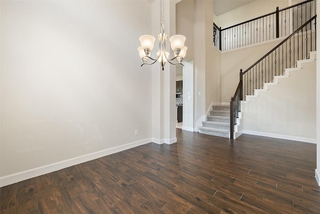 3351 Vasquez Pl, Round Rock, TX 78665 - unfurnished dining area with stairs, a chandelier, dark wood-style flooring, and a towering ceiling