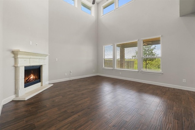 3351 Vasquez Pl, Round Rock, TX 78665 - unfurnished living room featuring a towering ceiling, wood finished floors, a premium fireplace, and ceiling fan