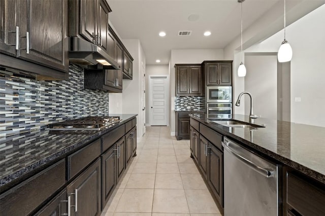 3351 Vasquez Pl, Round Rock, TX 78665 - kitchen featuring stainless steel appliances, under cabinet range hood, dark brown cabinetry, backsplash, and light tile patterned flooring