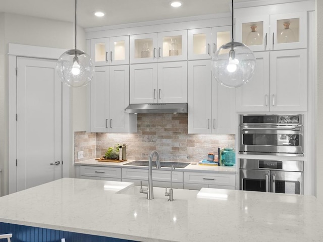105 Monterey Oak Trl, Georgetown, TX 78628 - kitchen featuring under cabinet range hood, black electric stovetop, white cabinets, backsplash, and glass insert cabinets