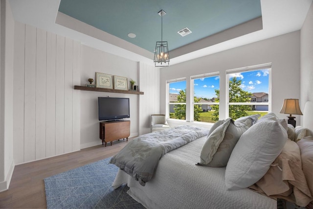 105 Monterey Oak Trl, Georgetown, TX 78628 - bedroom featuring a chandelier, wood finished floors, a tray ceiling, and baseboards