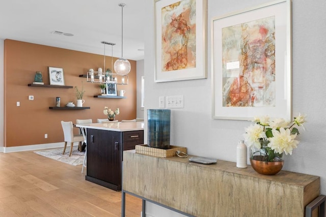 105 Monterey Oak Trl, Georgetown, TX 78628 - bar with light wood-style flooring, pendant lighting, and baseboards