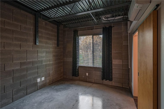 unfurnished room featuring concrete flooring and a wall unit AC