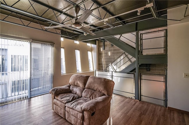 living area with plenty of natural light, wood finished floors, and baseboards