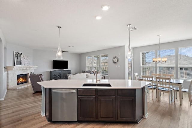 270 Johnny Cake Dr, Kyle, TX 78640 - kitchen featuring a sink, stainless steel dishwasher, a brick fireplace, light countertops, and recessed lighting