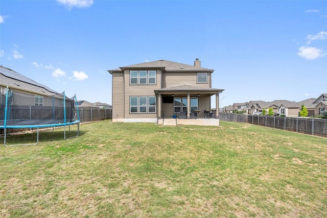 270 Johnny Cake Dr, Kyle, TX 78640 - back of property featuring a trampoline, a chimney, a patio, and a residential view