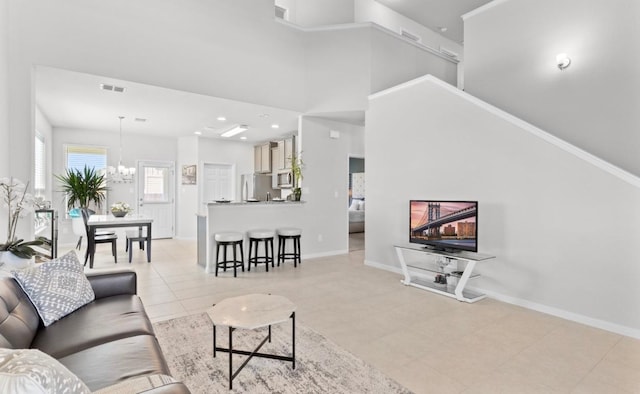 246 Salt Springs Rd, Kyle, TX 78640 - living room featuring a chandelier, baseboards, and light tile patterned floors
