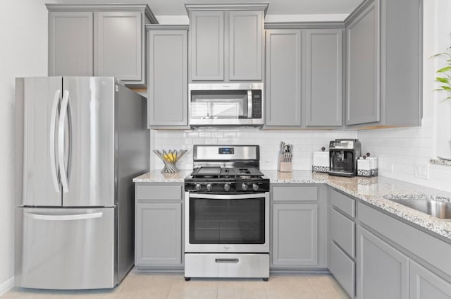 246 Salt Springs Rd, Kyle, TX 78640 - kitchen featuring stainless steel appliances, gray cabinets, and decorative backsplash
