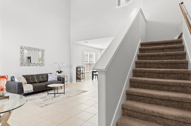 246 Salt Springs Rd, Kyle, TX 78640 - staircase featuring a towering ceiling, tile patterned flooring, and baseboards