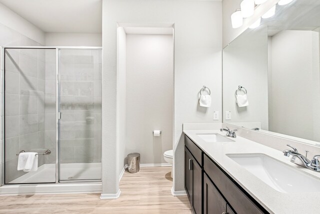 11 Bent Trail Ln, Georgetown, TX 78628 - bathroom featuring double vanity, wood finished floors, a shower stall, toilet, and baseboards