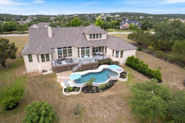 209 Steamboat Xing, Dripping Springs, TX 78620 - back of property with a chimney, a fenced backyard, an outdoor pool, a wooden deck, and stone siding