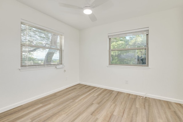 spare room with light wood finished floors, ceiling fan, and baseboards