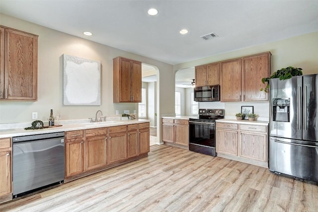 227 Woodlake Dr, Georgetown, TX 78633 - kitchen with appliances with stainless steel finishes, light wood-style floors, light countertops, recessed lighting, and arched walkways