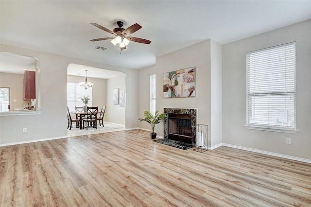 227 Woodlake Dr, Georgetown, TX 78633 - living room with wood finished floors, a ceiling fan, a chandelier, and a fireplace