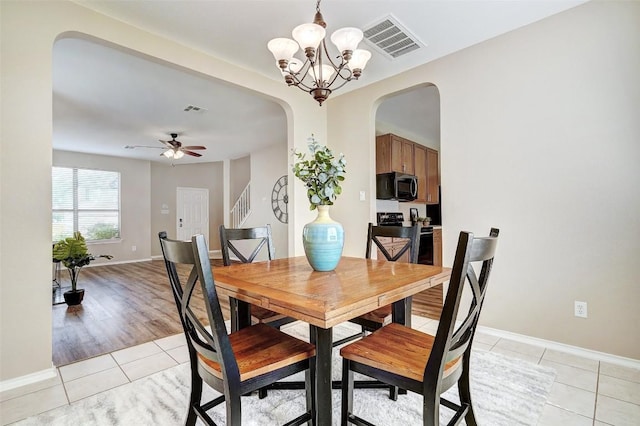 227 Woodlake Dr, Georgetown, TX 78633 - dining space with light tile patterned flooring, arched walkways, a chandelier, and ceiling fan