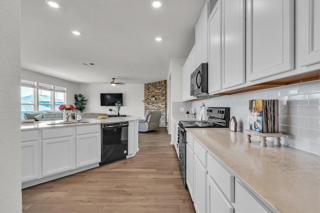 282 Crimson Ln, Kyle, TX 78640 - kitchen featuring black appliances, open floor plan, a sink, white cabinetry, and recessed lighting