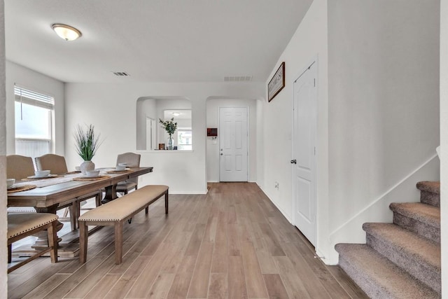 282 Crimson Ln, Kyle, TX 78640 - dining area featuring arched walkways, light wood-style flooring, stairway, and baseboards