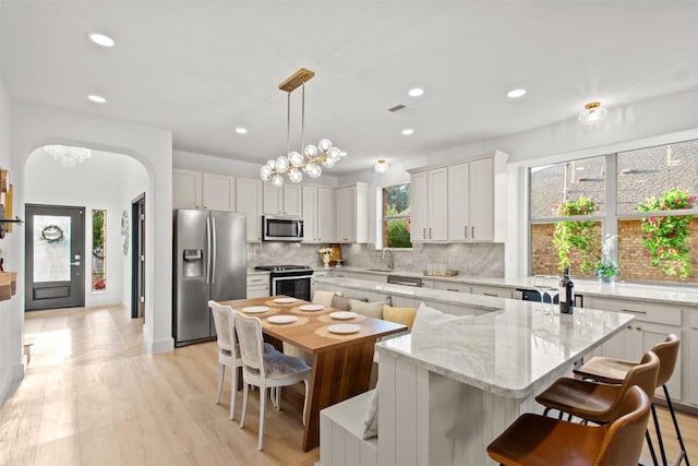286 Stone View Trl, Austin, TX 78737 - kitchen with appliances with stainless steel finishes, a kitchen island, a sink, tasteful backsplash, and recessed lighting