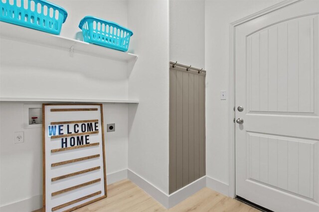 286 Stone View Trl, Austin, TX 78737 - clothes washing area with electric dryer hookup, hookup for a washing machine, light wood-style flooring, and baseboards