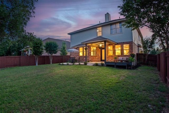 286 Stone View Trl, Austin, TX 78737 - back of house at dusk with brick siding, a chimney, and a patio area