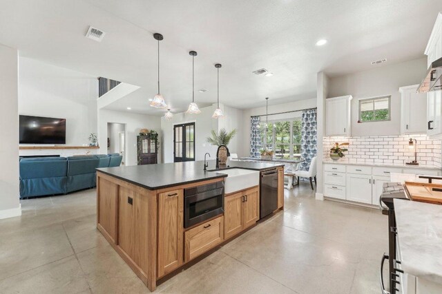 795 Van Bibber Rd, Salado, TX 76571 - kitchen featuring black dishwasher, built in microwave, a sink, decorative backsplash, and an island with sink