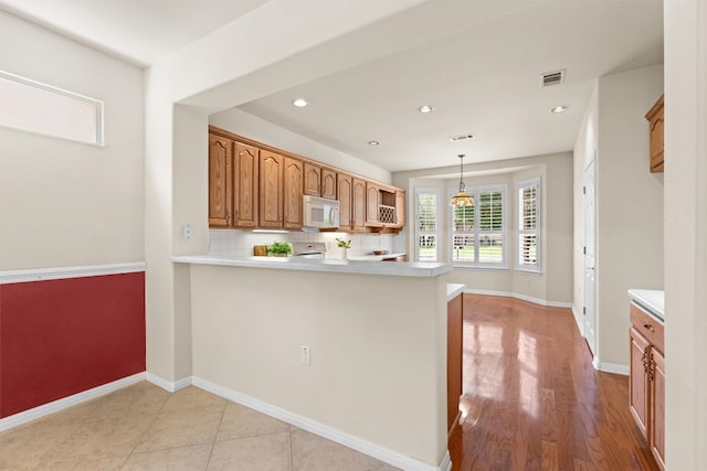 403 Dove Hollow Trl, Georgetown, TX 78633 - kitchen with white microwave, light countertops, a peninsula, recessed lighting, and pendant lighting