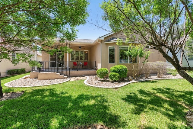 403 Dove Hollow Trl, Georgetown, TX 78633 - back of property with a ceiling fan, stucco siding, a yard, and covered porch