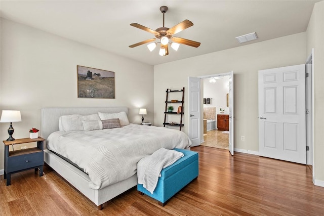 bedroom with wood finished floors, baseboards, connected bathroom, and a ceiling fan