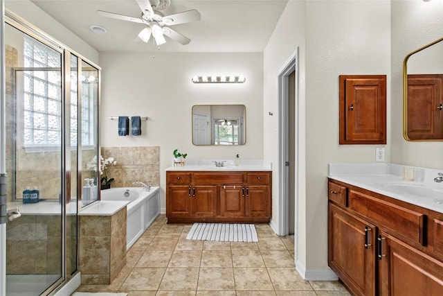 bathroom with a ceiling fan, a stall shower, a garden tub, tile patterned floors, and two vanities