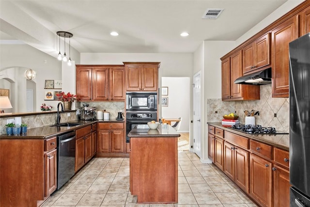 kitchen featuring black appliances, a sink, under cabinet range hood, backsplash, and a peninsula