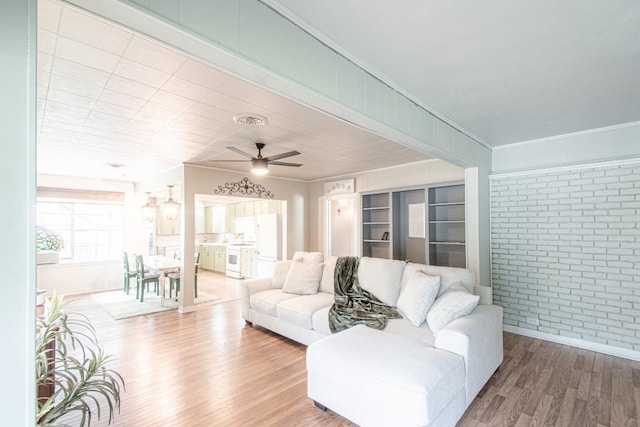 1408 W Clark St, Bartlett, TX 76511 - living area featuring ornamental molding, brick wall, wood finished floors, ceiling fan, and baseboards